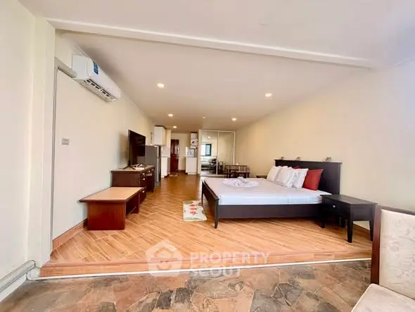 Spacious open-plan living area with modern furnishings and wooden flooring, ideal for comfortable urban living.