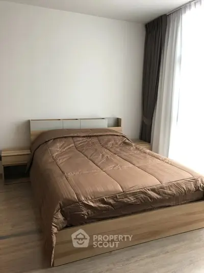 Modern bedroom with cozy bed and natural light, perfect for relaxation.