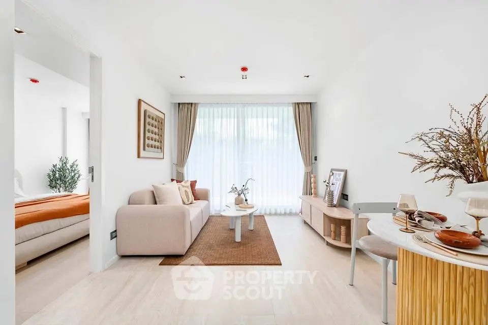 Modern living room with elegant decor and natural light, featuring a cozy sofa and stylish furnishings.