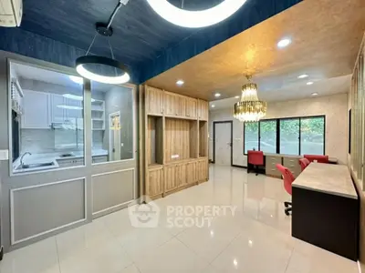 Spacious modern living room with elegant chandelier and open kitchen layout