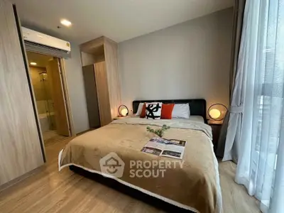 Modern bedroom with cozy decor and ensuite bathroom in stylish apartment.