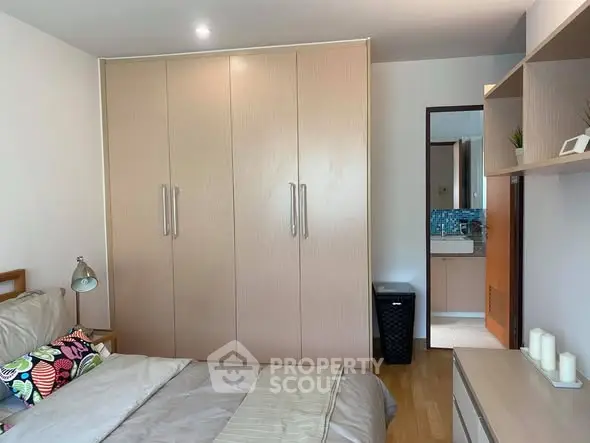 Cozy bedroom with built-in wardrobe and ensuite bathroom, perfect for modern living.
