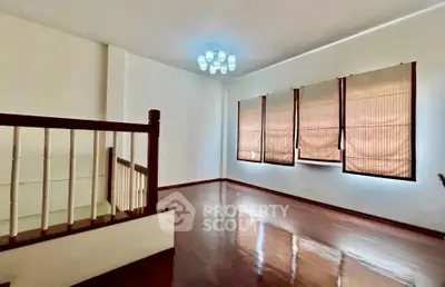 Spacious living room with wooden flooring and elegant lighting in a modern home.