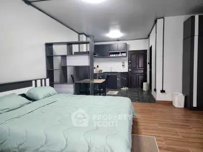 Spacious studio apartment with modern kitchen and cozy sleeping area, perfect for urban living.