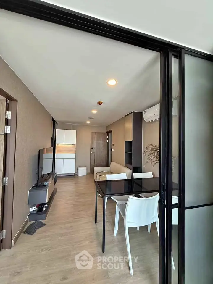 Modern living room with sleek furniture and open layout, featuring a dining area and stylish decor.