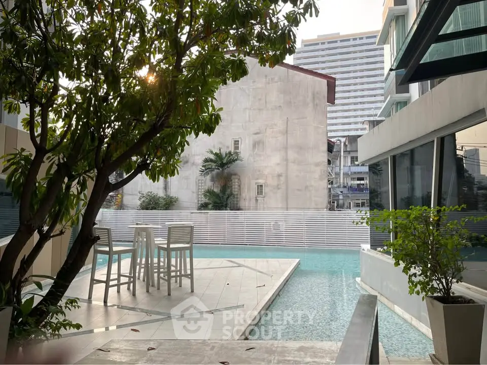Luxurious poolside area with modern architecture and lush greenery, perfect for relaxation and leisure.