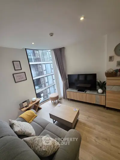 Modern living room with large window and stylish decor in urban apartment