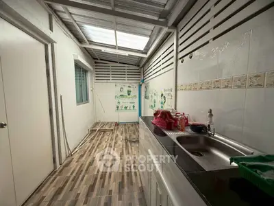 Charming utility area with modern sink and tiled flooring, perfect for practical home tasks.