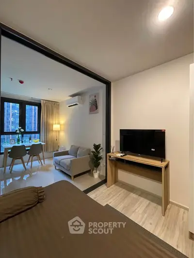 Modern apartment interior with cozy living room and dining area, featuring stylish furniture and natural light.