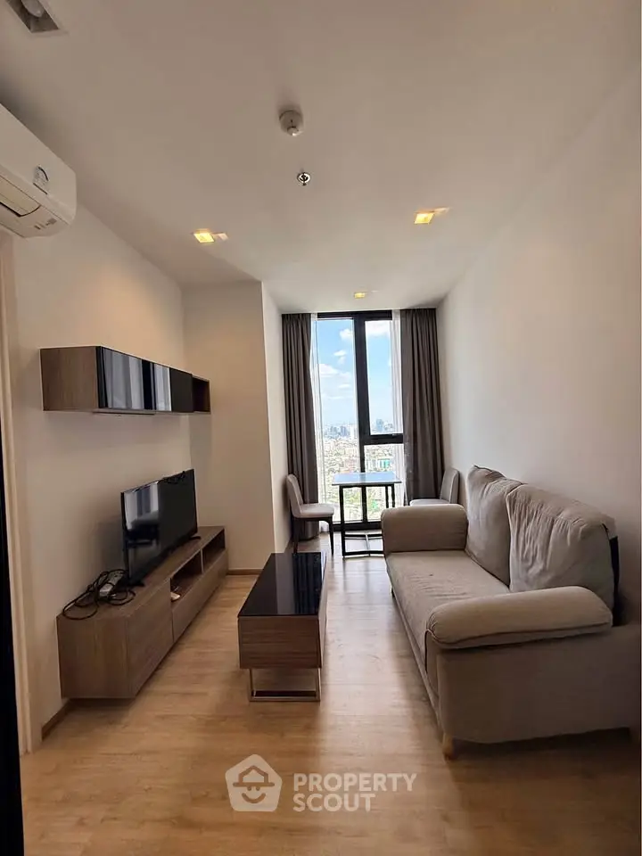 Modern living room with city view, featuring sleek furniture and natural light.