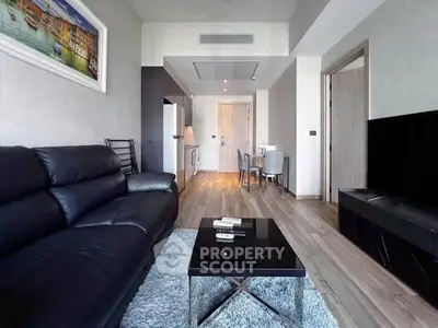 Modern living room with sleek black leather sofa and stylish decor in a contemporary apartment.