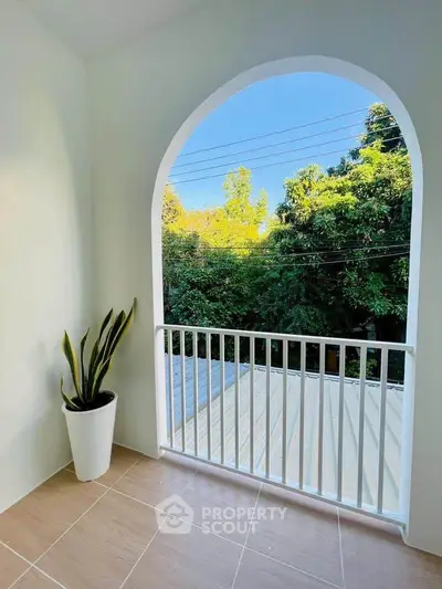 Charming balcony with lush green view and elegant arch design