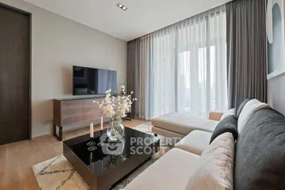 Elegant living room with modern decor, large TV, and floor-to-ceiling windows.