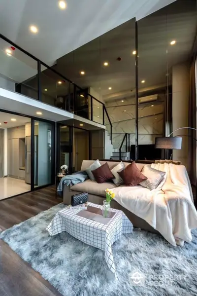 Luxurious modern living room with high ceiling and mezzanine, featuring cozy sofa and stylish decor.