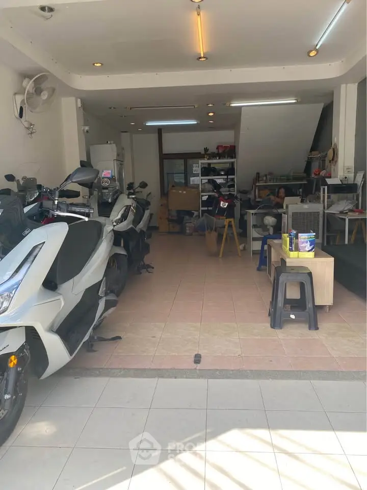 Spacious garage with motorbikes and storage area, ideal for vehicle enthusiasts.