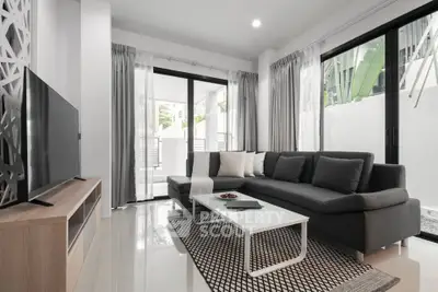 Modern living room with sleek furniture and large windows offering natural light.