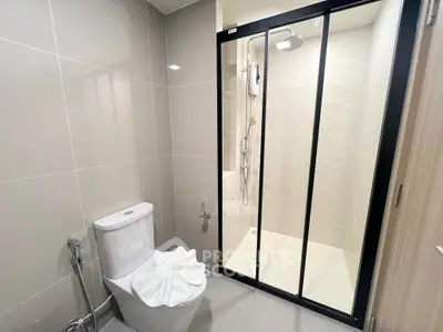 Modern bathroom with sleek shower and elegant fixtures in a contemporary apartment.