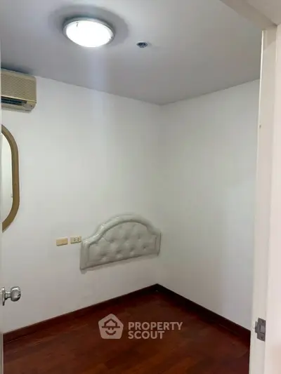 Cozy small bedroom with wooden flooring and wall-mounted headboard