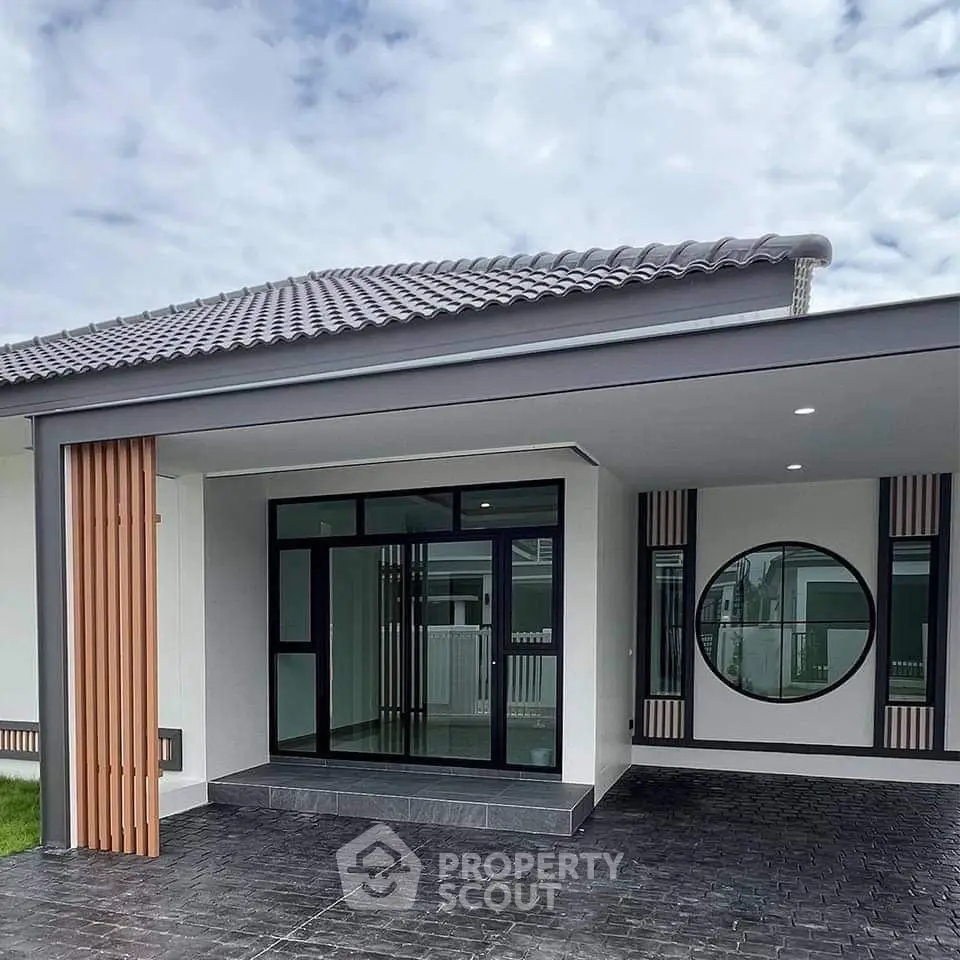 Modern single-story house with stylish facade and circular window design.