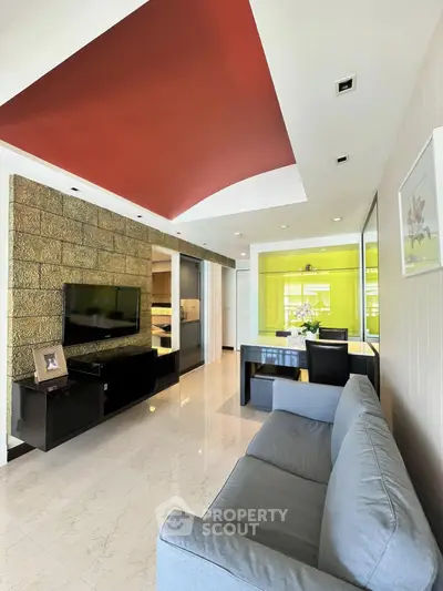 Modern living room with stylish red ceiling and elegant stone accent wall, featuring a cozy gray sofa and sleek TV unit.