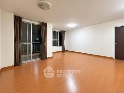 Spacious empty living room with wooden flooring and large windows