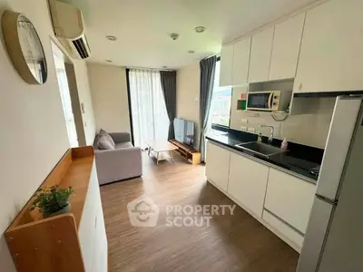 Modern open-layout kitchen and living room with sleek appliances and natural light.