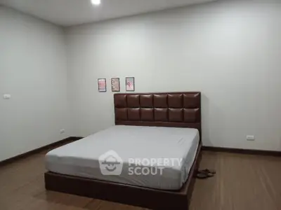 Spacious minimalist bedroom with modern bed and wooden flooring