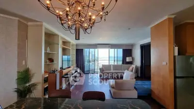 Spacious living room with modern chandelier and stunning ocean view.
