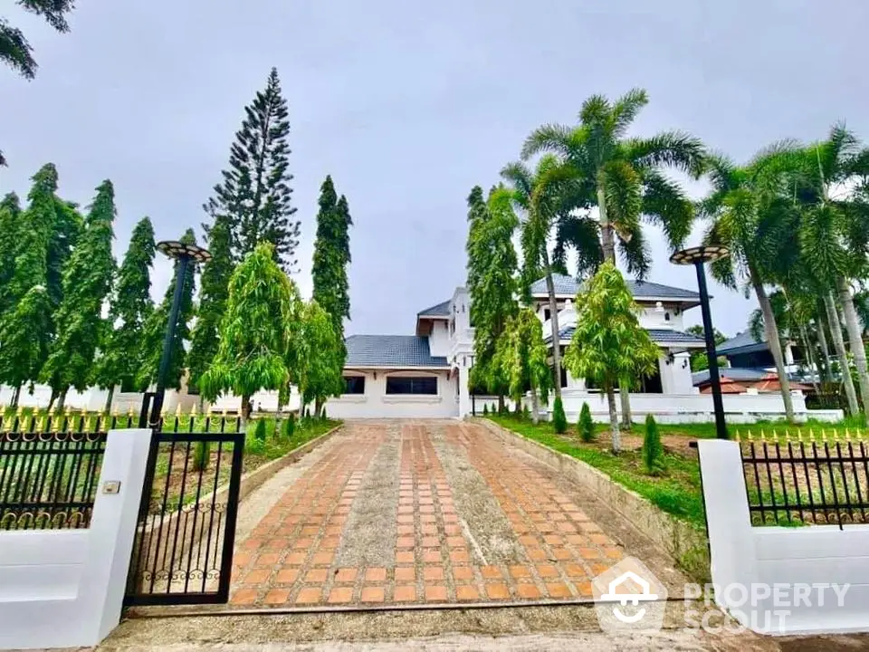 Stunning gated entrance to a luxurious estate with lush landscaping and elegant architecture.