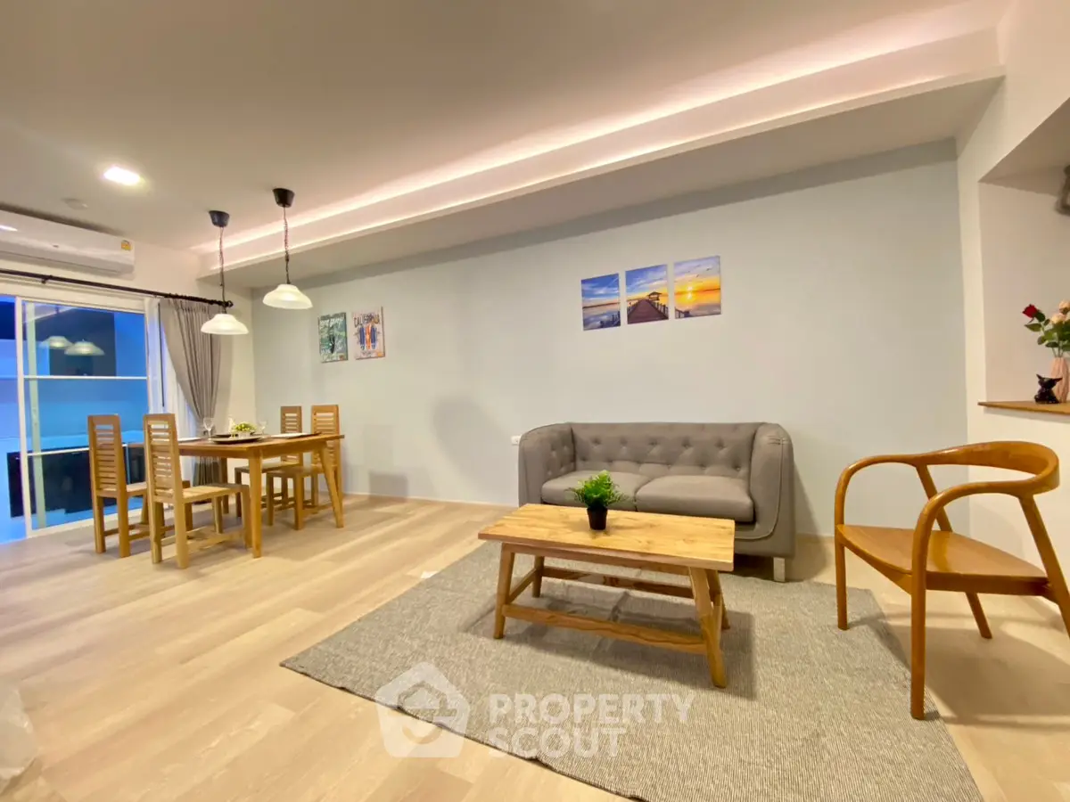 Spacious modern living room with dining area, featuring stylish furniture and elegant lighting.