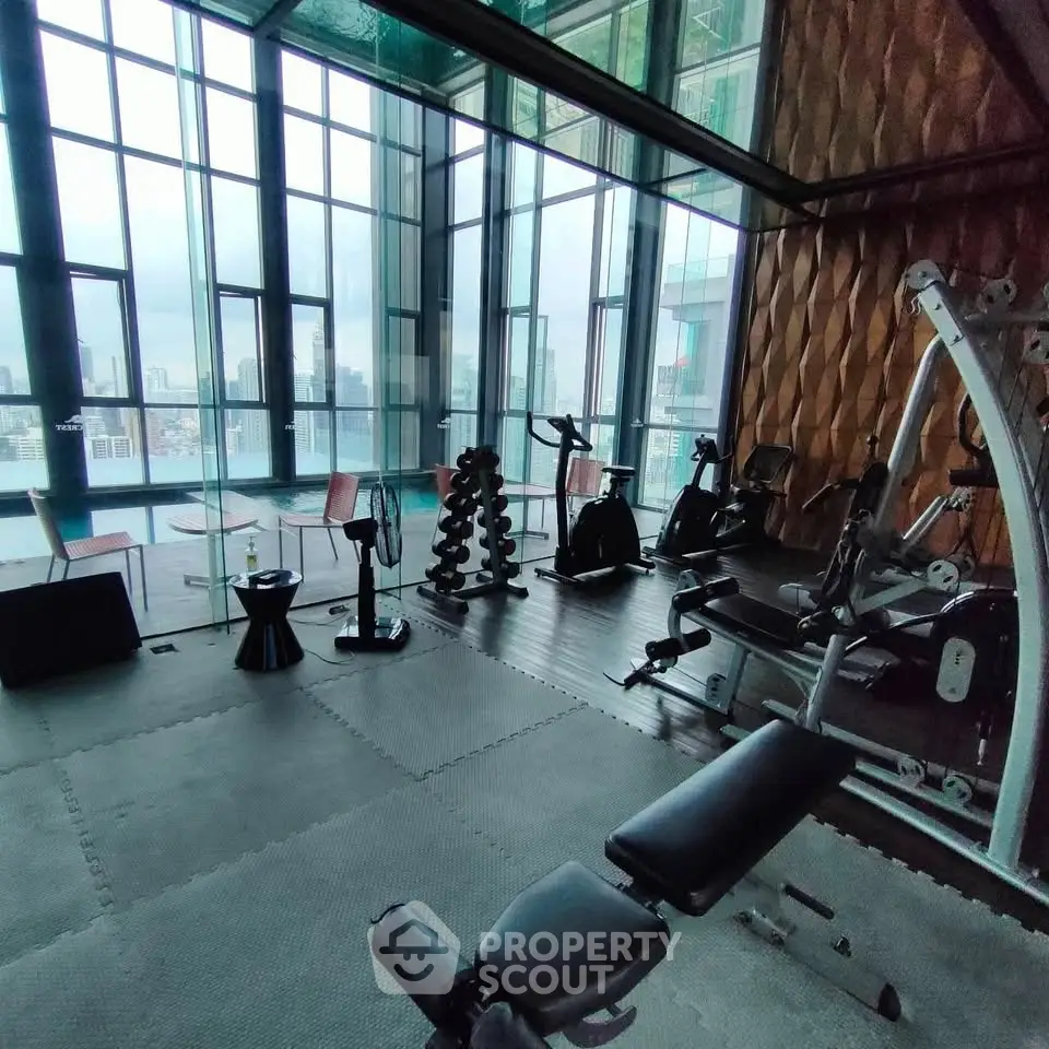 Luxurious high-rise gym with panoramic city views and modern fitness equipment.