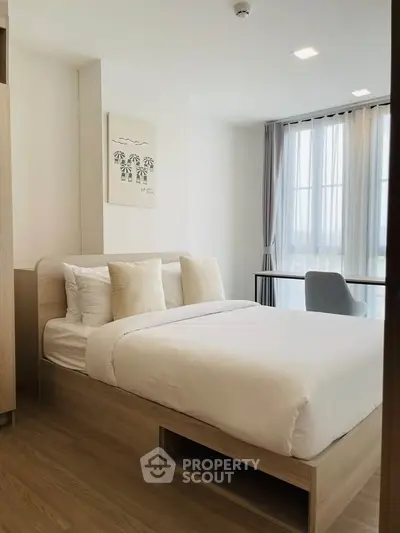 Modern bedroom with natural light and minimalist decor in a stylish apartment.