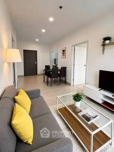 Modern living room with stylish decor and open layout, featuring a cozy sofa and dining area.