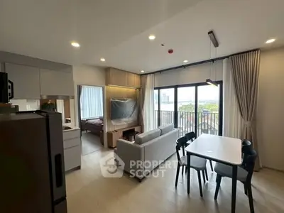 Modern open-plan living room with dining area and balcony view in stylish apartment.