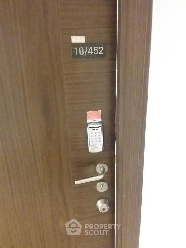 Modern apartment door with electronic lock and sleek wooden finish.