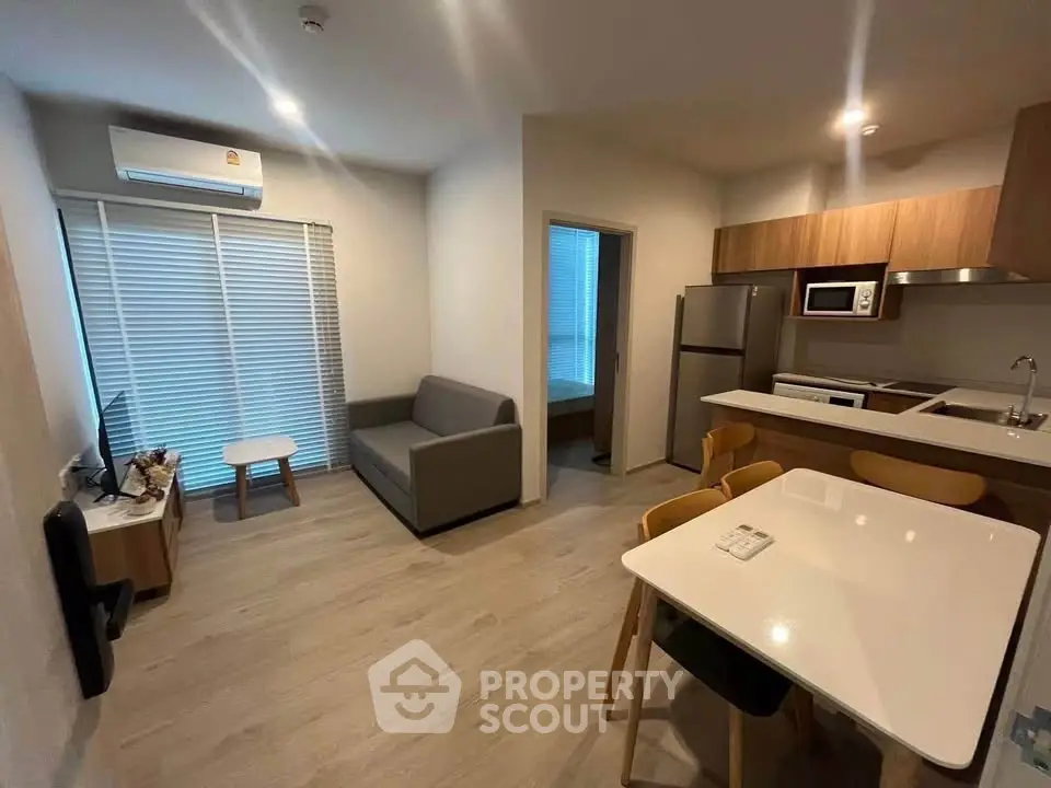 Modern open-plan living room with kitchen, featuring sleek furniture and contemporary design.