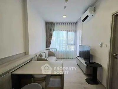 Modern living room with sleek furniture and large window, featuring air conditioning and a flat-screen TV.