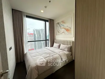 Modern bedroom with city view, featuring elegant decor and large window for natural light.