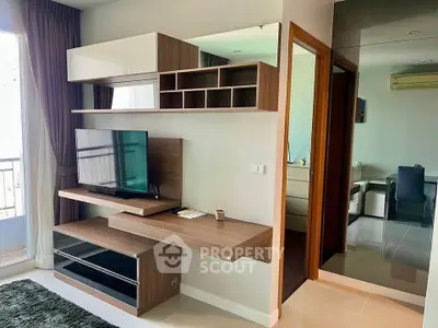 Modern living room with sleek TV unit and balcony access in stylish apartment.