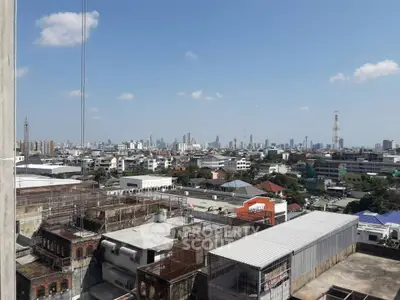 Stunning cityscape view from a high-rise building, showcasing urban skyline and clear blue sky.