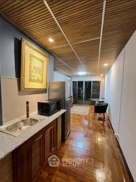Stylish kitchen with modern appliances and cozy living area in open layout apartment.