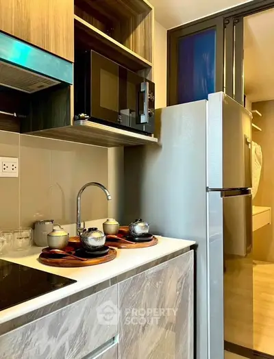 Modern kitchen with sleek appliances and stylish cabinetry in a compact layout.