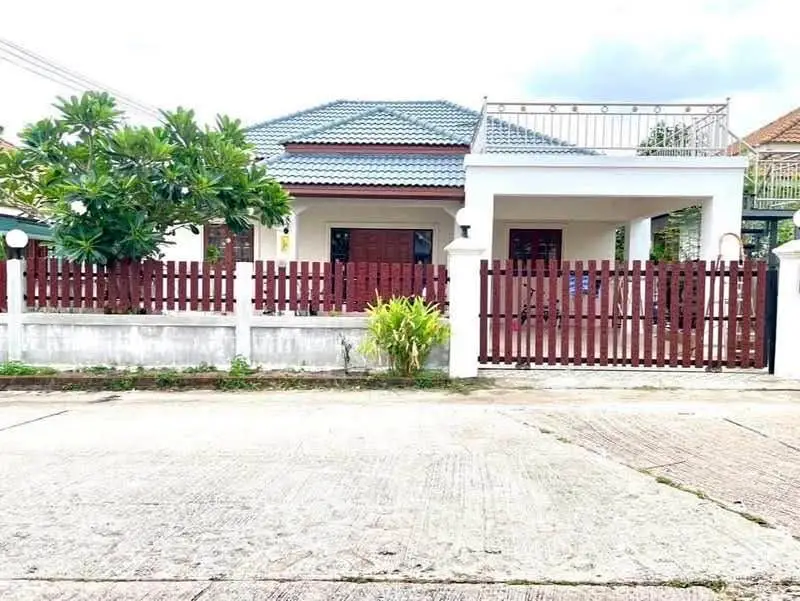 Charming single-story house with a fenced yard and rooftop terrace, perfect for family living.