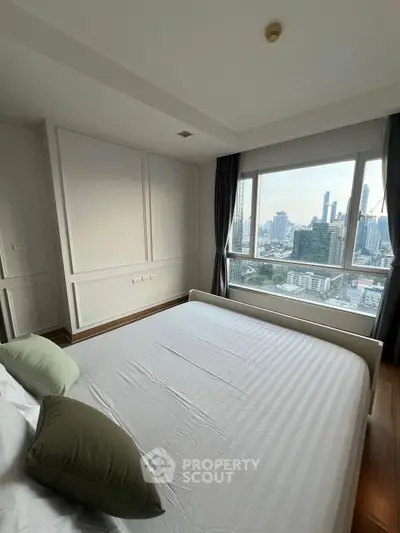 Modern bedroom with city view, large window, and stylish decor