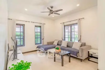 Bright and cozy living room with modern decor and large windows.