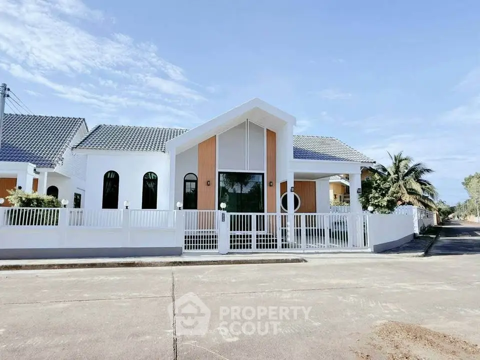Modern single-story house with stylish facade and gated entrance in a serene neighborhood.