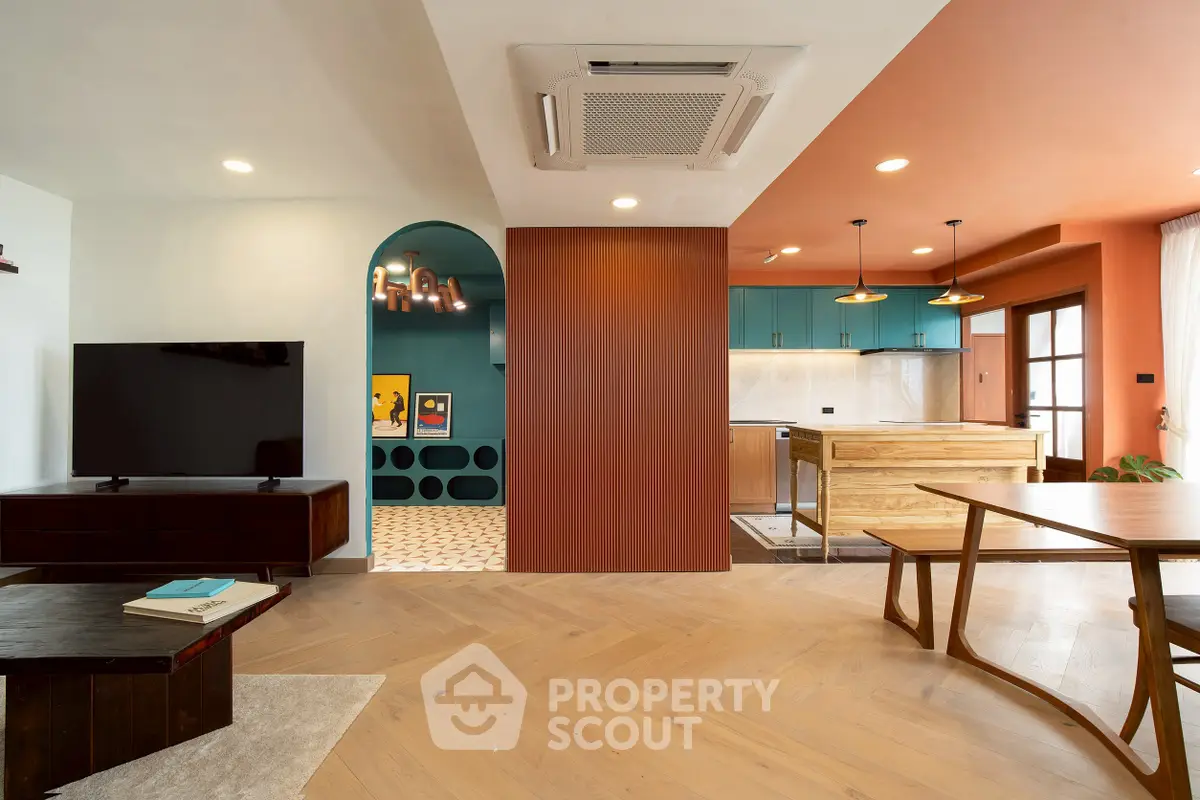 Modern open-concept living room with stylish kitchen and wooden flooring