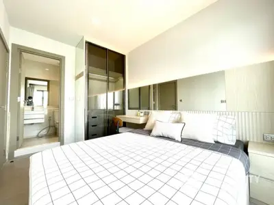 Modern bedroom with ensuite bathroom and stylish decor in a bright apartment.