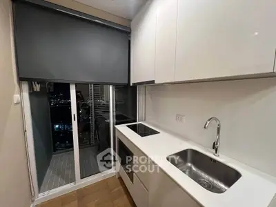 Modern kitchen with sleek white cabinets and city view balcony access