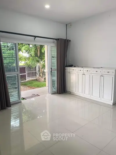 Spacious living room with garden view and elegant white cabinetry.